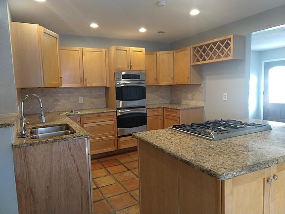 New kitchen with stainless steel appliances, granite, island cook top