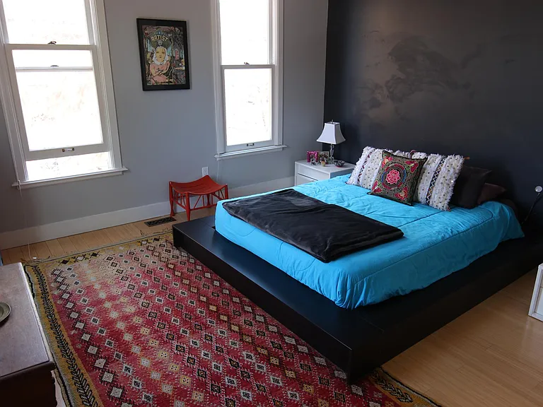 Master bedroom. The windows feature blackout shades. The dark charcoal wall has been recently repainted light gray. The master bedroom features a spacious closet.