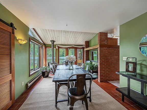Dining area complete with woodstove and view of the lake