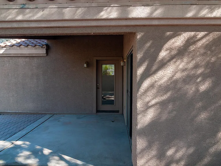 covered patio, sliding door to living room on right, door to master bedroom at center
