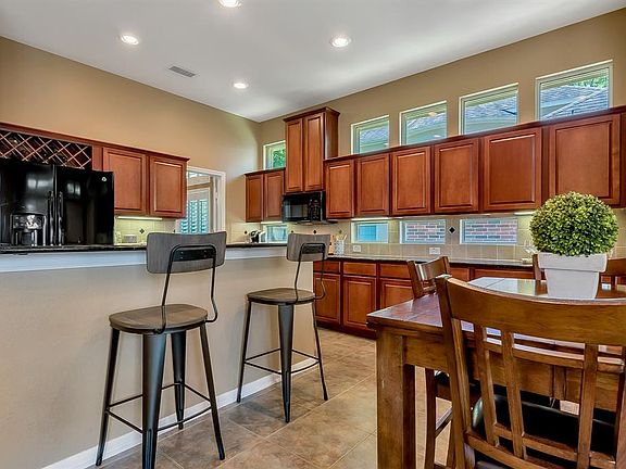 The amazing open concept Kitchen is filled with natural light, abundant full-sized cabinetry, island/breakfast bar, and granite countertops.