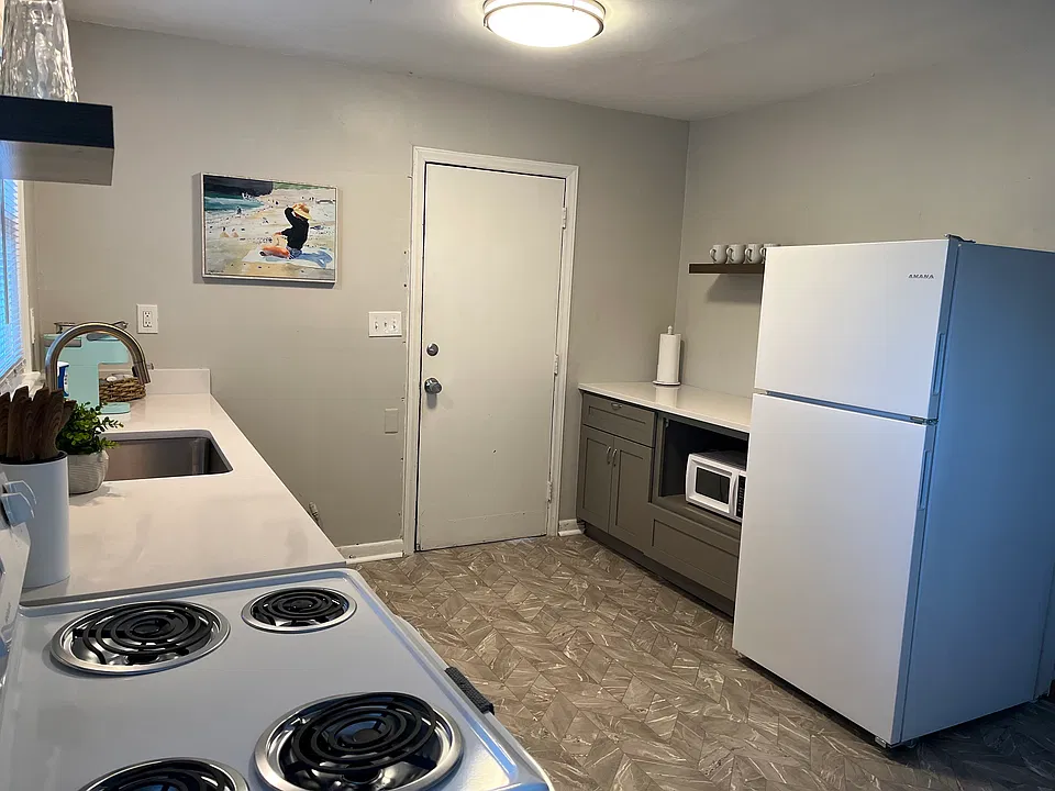 Full kitchen with generous counter space, refrigerator, range, and microwave.