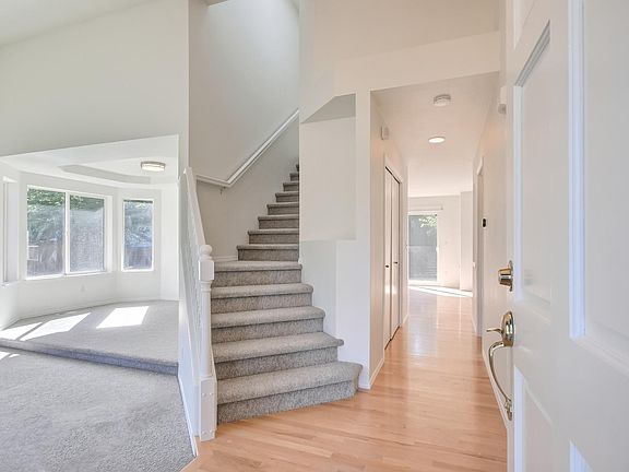 Entry foyer with staircase going up, formal living room on the left attached to the dining room