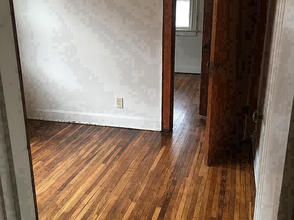 Hardwood floor in middle small bedroom connecting to rear sm