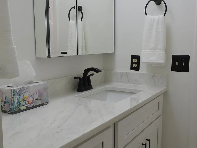 Primary marble countertop and sink.
New porcelain tile floors. All new cabinetry.