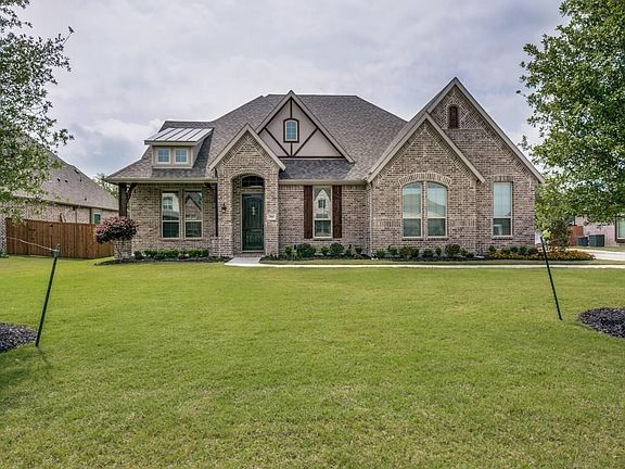 Inviting covered front porch, cedar accents, standing seam roof and beautiful solid wood door with speakeasy!