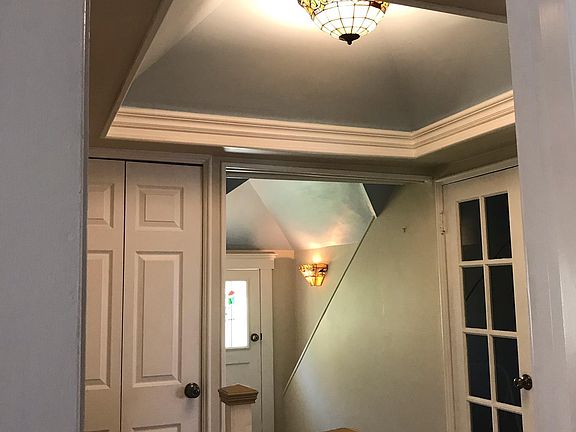 at top of stairs showing doors to two storage rooms (left and right)
and hallway leading to balcony entrance on left. Bedroom and living room entrances
are on right but not shown. Note fancy vaulted ceiling with leaded glass chandelier
