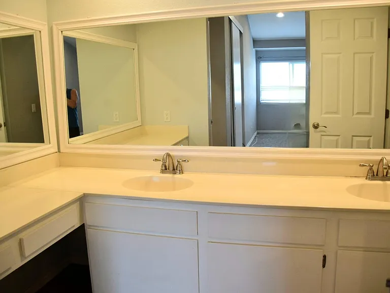 Vanity area on left with room for a chair and double sinks.