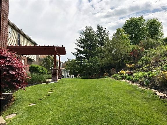 Another view of the rear yard and patio with pergola