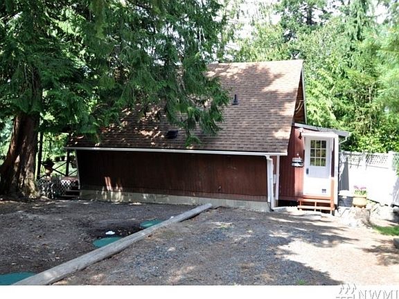 Front/side of home. The Cabin sits sideways on the lot to maximize the view out the back of the Cove and the Sound. Entry is thru the laundry room/Mud entrance. Home comes with both washer and dryer.