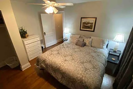 Back Bedroom with King bed, TV, dresser, closet, lots of windows & blackout curtains