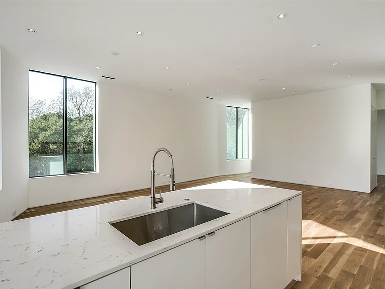 Modern kitchen island with a large stainless steel sink and gooseneck faucet