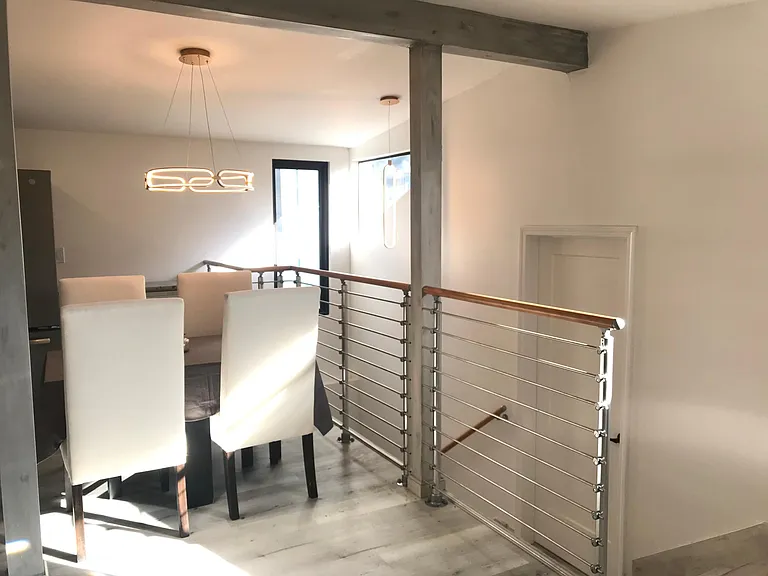 Dining area next to custom gourmet kitchen & staircase leading to downstairs master bedroom.