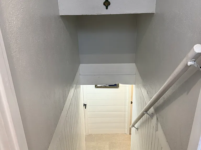 shared staircase to separate basement areas with Washer/Dryer