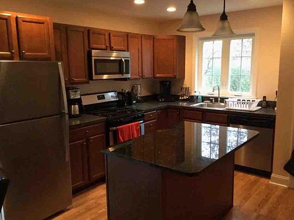 KItchen with granite island, gas range / oven and S/S appliances.