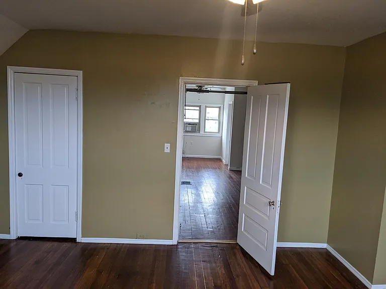 Large third floor bedroom with newly refinished hardwood floors.