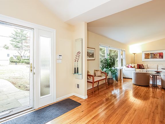 Entry with view outside and looking into the living room. Gleaming hardwood floors throughout.