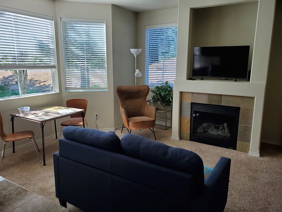 second seating area in front of fireplace and TV and games table under the bow window. abundant natural light
