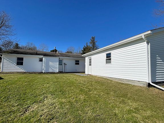 View back of house (has small attached storage space). View side of garage.