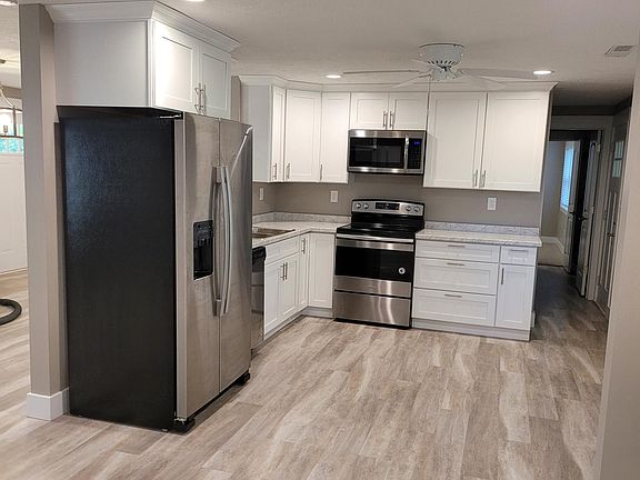 Extremely well appointed light/bright kitchen, complete with brand new shaker style white cabinets, brand new stainless steel appliances, and new Shaw waterproof vinyl plank flooring