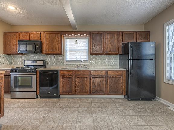 Kitchen with Refrigerator, dishwasher, stove and microwave.