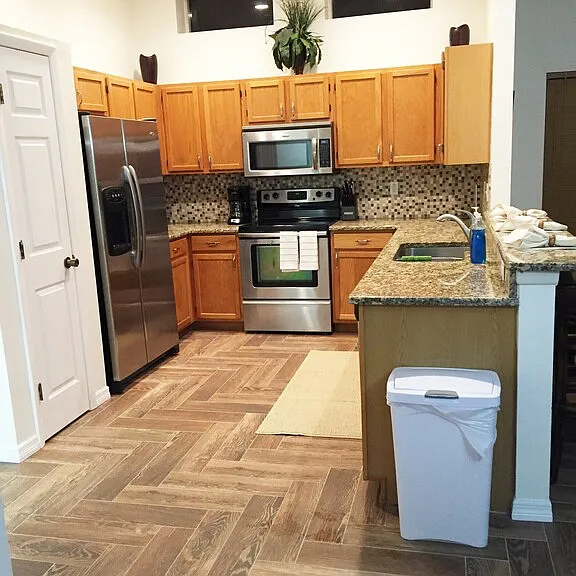 Large open kitchen with stainless appliances and full pantry. Large bar area with granite going into family room. Home has herringbone tile throughout entire home.