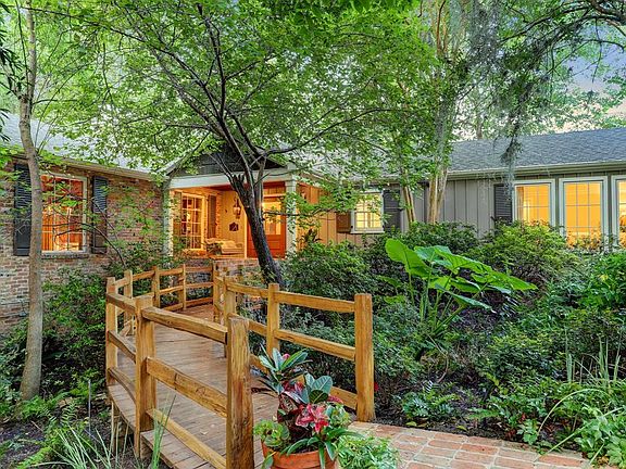 Welcome to this amazing " the cottage in the woods"!A truly private residence surrounded by lush landscaping and differing elevations in topography. The brick walkway and custom footbridge are inviting features to the charming home.