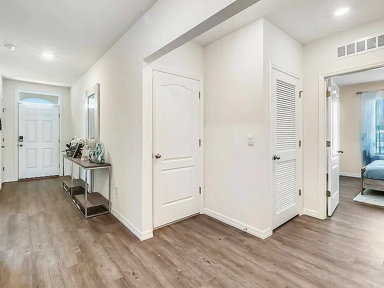 Step into comfort with this beautifully lit entryway, featuring modern touches and ample space.