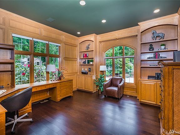The office or study is located through French doors off the foyer; this fully paneled room has dark hardwood flooring and built-in cabinets and bookshelves. The guest powder bath is off the foyer and has been remodeled with a furniture style vanity having a slab granite top, maple wainscoting, and easy to clean TOTO toilet.
