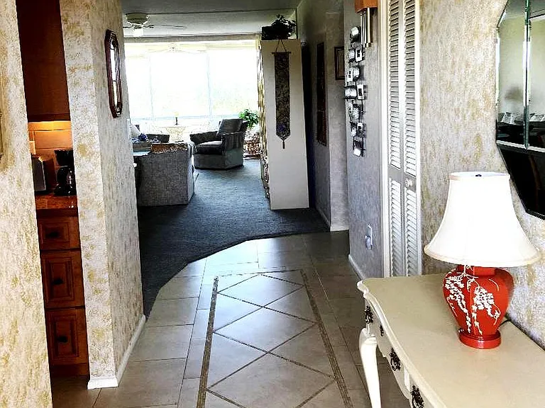 View through entrance hall through condo. Custom kitchen is accessed through doorway shown on left.