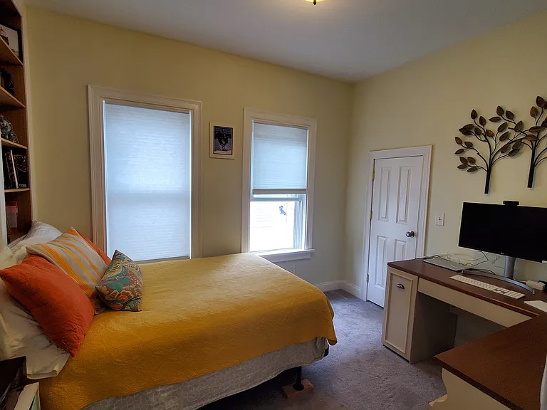 Bedroom 3 with a full bed, built in shelves, and desk
