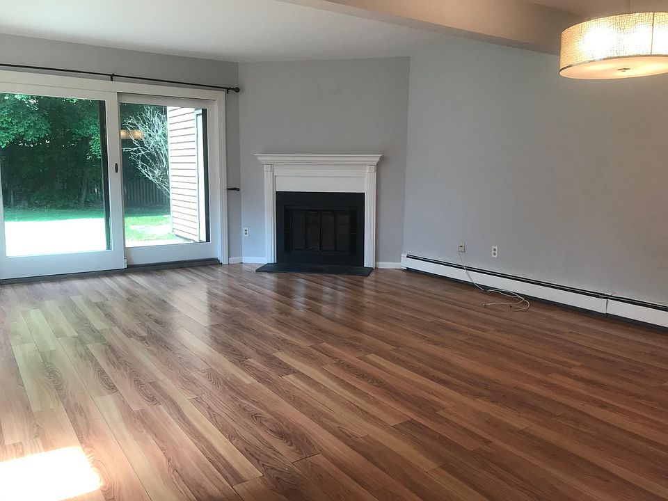 Spacious living room with wood-burning fireplace and oversized sliding glass doors to a private patio and large yard - great for barbequing and entertaining!