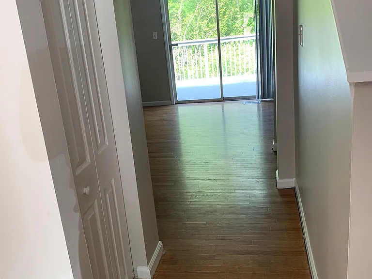 Hallway as you walk in, kitchen to your left. Sizable pantry door shown on left for additional food, cleaning supplies, etc. Back 2nd floor/main floor deck with stairs down to the lower deck.