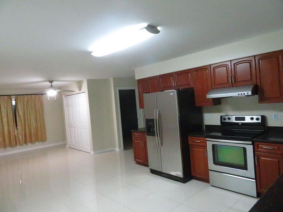 View just entering house. The double doors in the photo are of the pantry area. (This photo has the old refrigerator.)