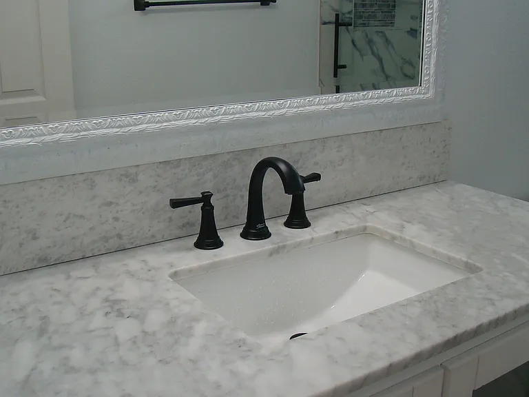 Close up of updated secondary bathroom sink with granite.