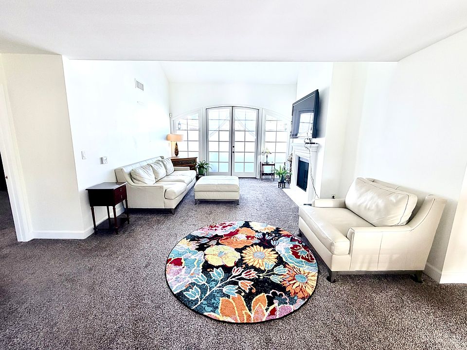 Large living room with vaulted ceilings with french doors to a private patio