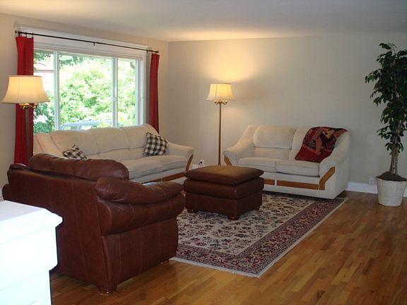 Large living room with hardwood floors and high grade windows & blinds