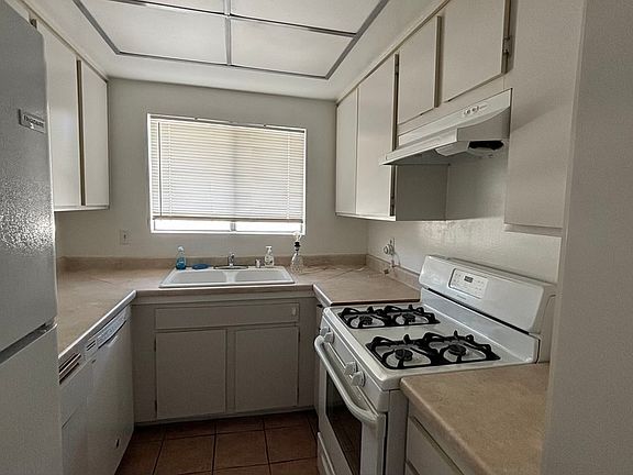 The kitchen includes a stove, dishwasher, and refrigerator.