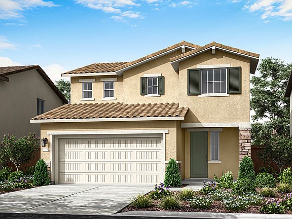 A two-story beige house with a tiled roof, a garage door, and a well-landscaped front yard with shru