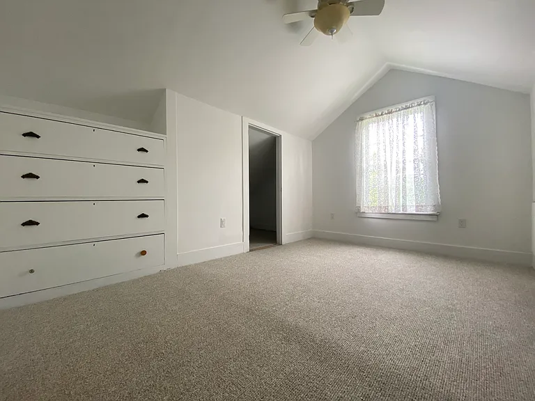 Third floor bedroom with large built in dresser, showing one of three closets