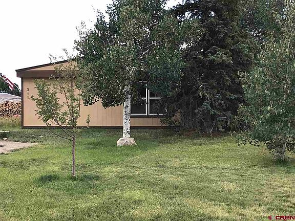 Grassy yard, mature trees, fenced back yard, graveled parking, sunny with East facing views.