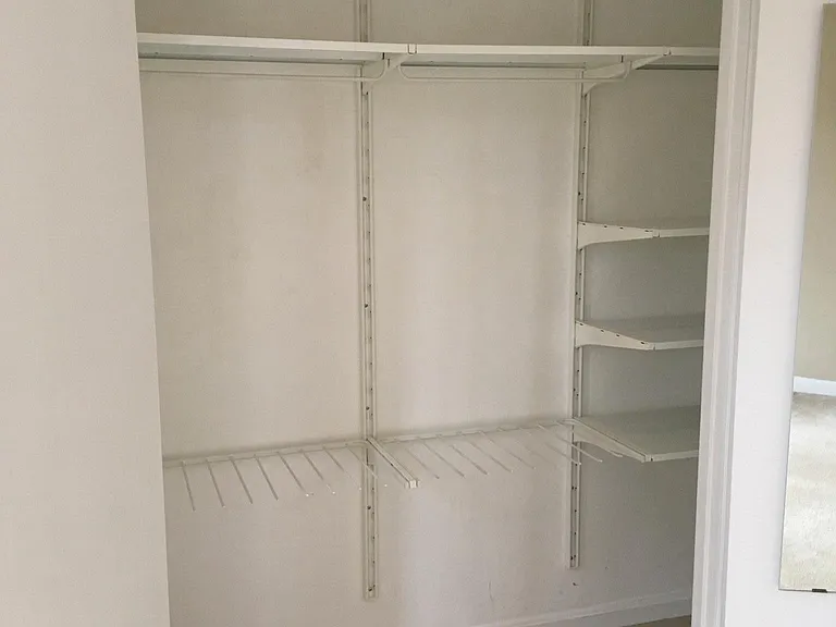 Bedroom closet with customizable Algol shelves and mirror