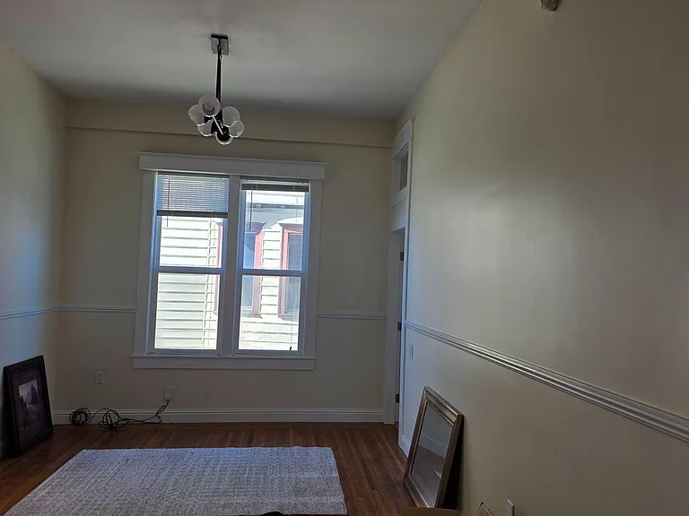 Versatile room with hardwood floors, wide windows, and overhead lightingideal for a dining area or home office setup.