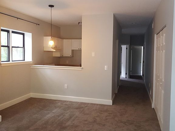 View of open floor plan showing dining room, kitchen, and ha