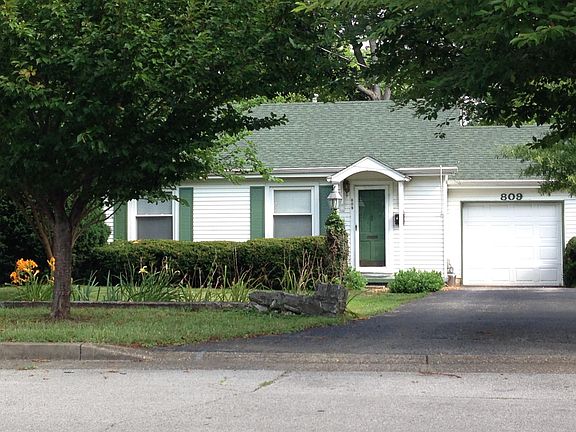 Mature trees and thoughtful landscaping surround the house.