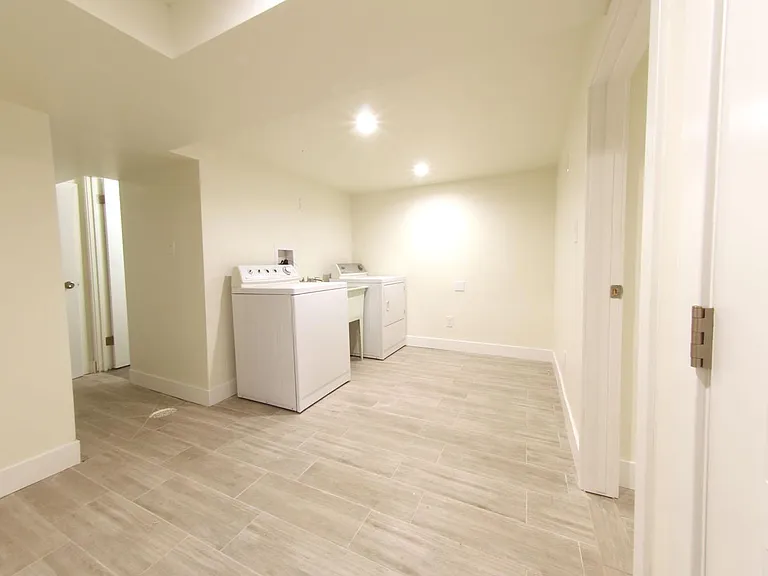 Full size laundry room with washer, dryer and utility sink. under stair storage and bedroom #5 to right.