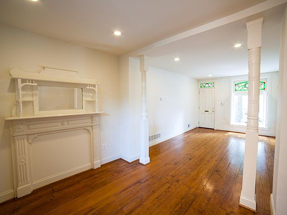 Dining and living rooms with historic fireplace and columns