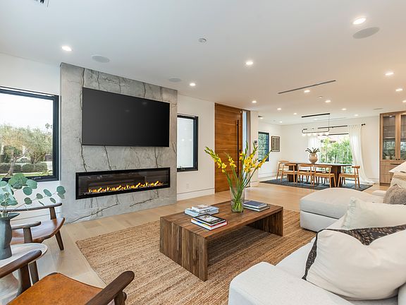 The living room features spacious floor to ceiling windows with an electric fireplace, surround sound and all you need for entertaining.