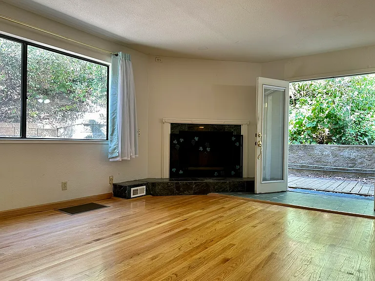 Inviting open floor layout with big windows and double doors leading to a private deck.