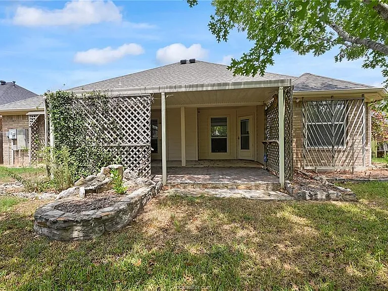 back of house view with lots of cement planter beds and covered patio